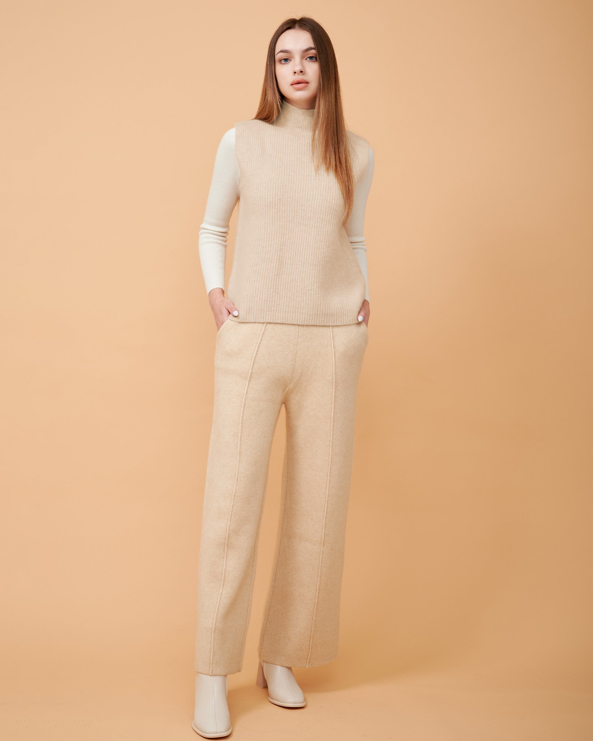 A front view of a cashmere vest coat in beige showing the straight-sided design , Very smooth cashmere design
