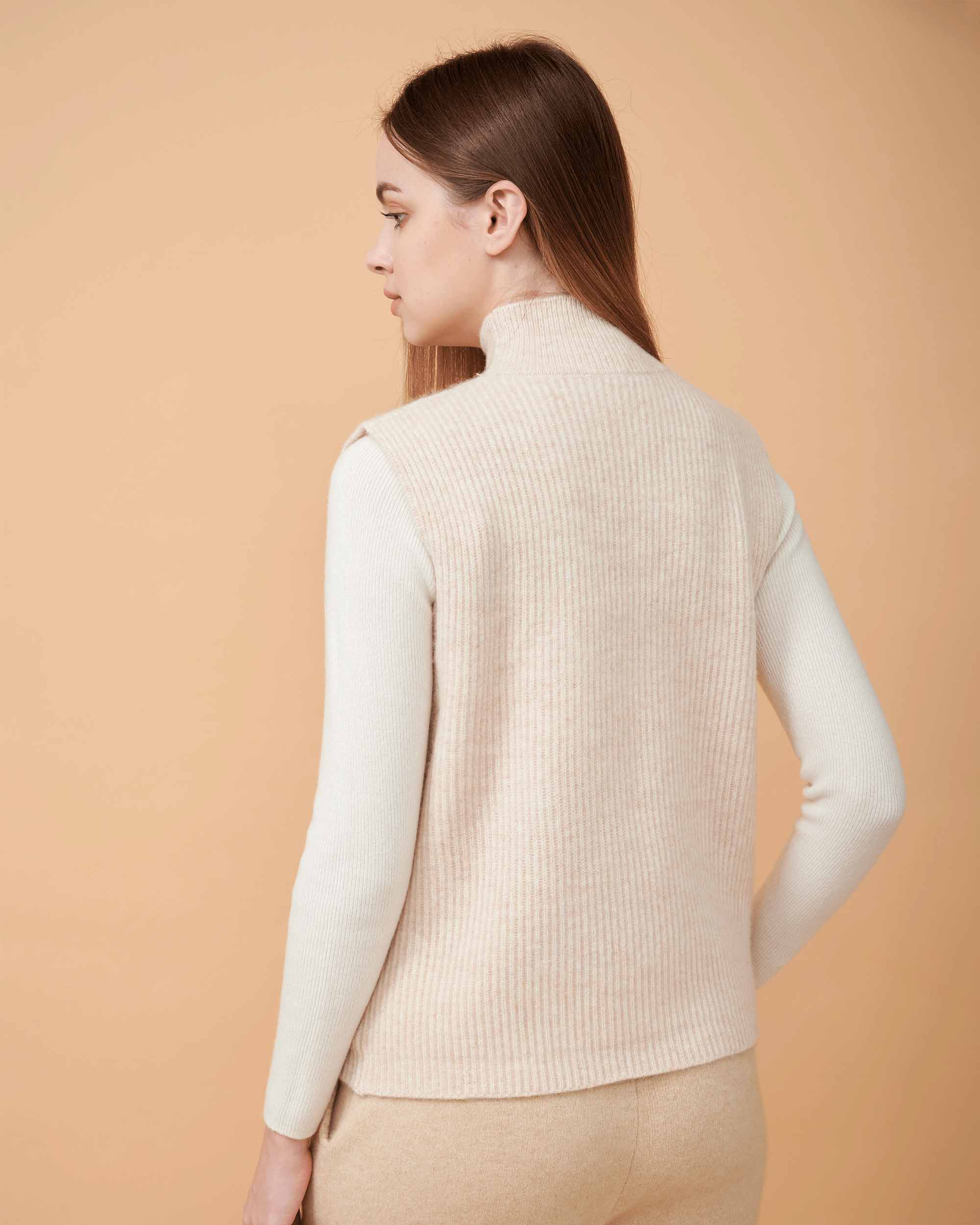A back view of a cashmere vest coat in creame showing the straight-sided design , Very smooth cashmere design