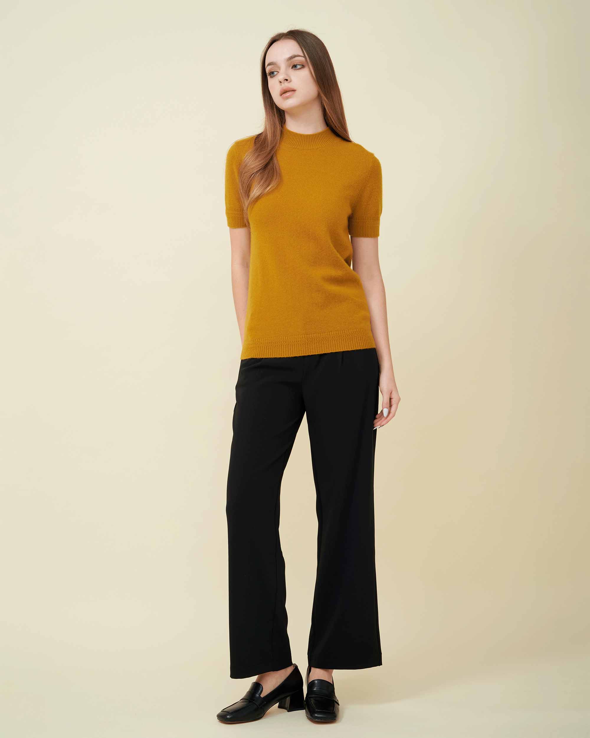 A front view of a cashmere pullover in mustard showing the length and fit