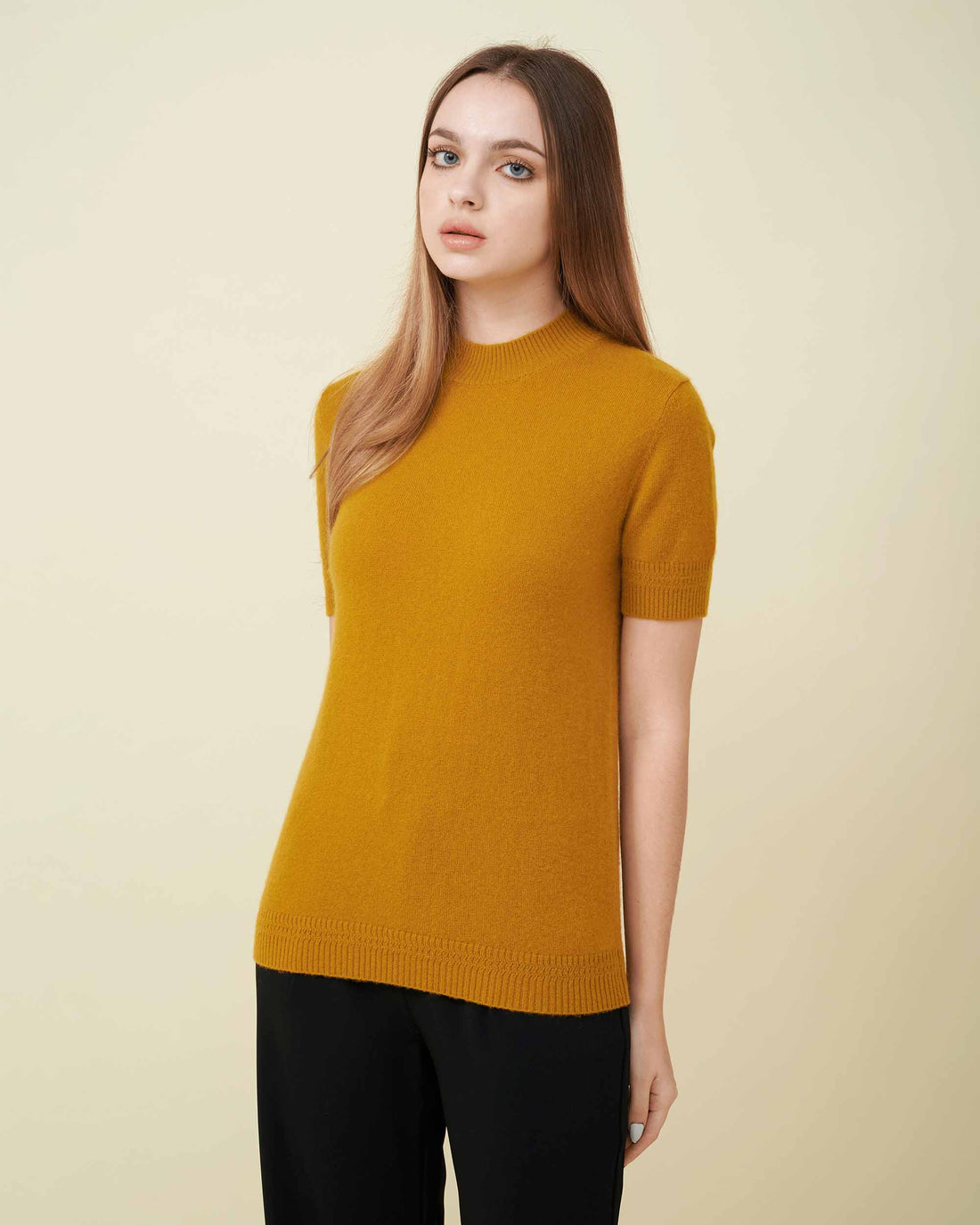 A front view of a cashmere pullover in mustard showing the length and fit