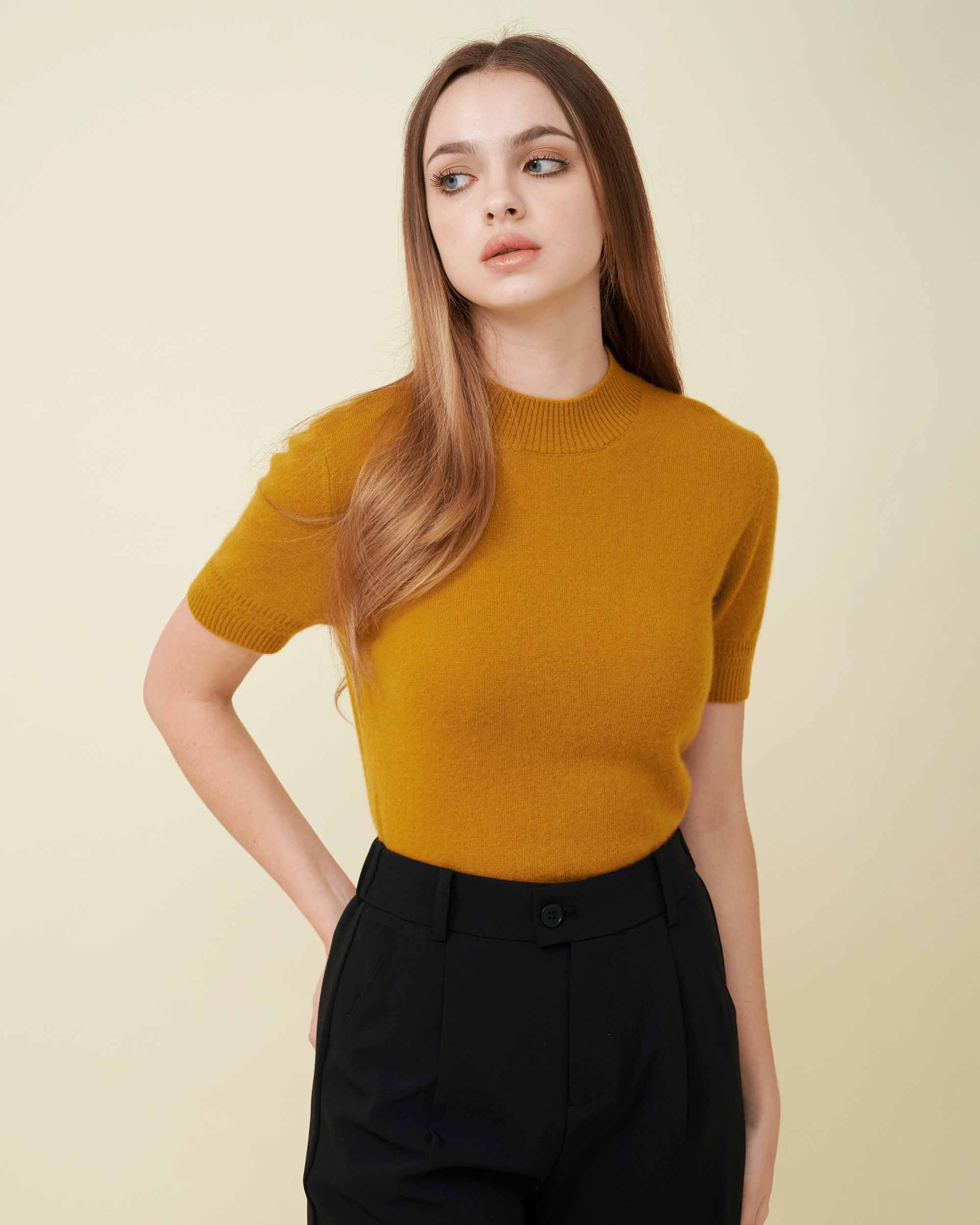 A Closeup view of a cashmere pullover in mustard showing the fit , 100% cashmere , Soft and comfy 